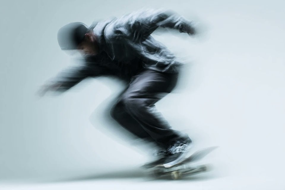 A blurred silhouette of a [Subject] in motion, wearing a ... - alternate