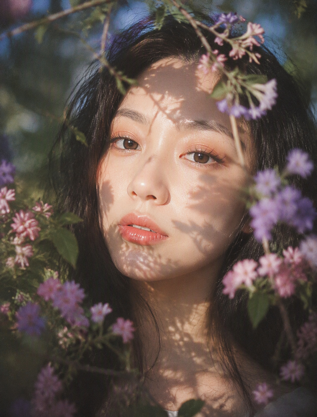 梦幻自然光花园人像,柔焦胶片质感,竖幅近距离肖像构图;年轻女性,muse般的面庞,黑色长发蓬松微乱,面部居中偏上作...