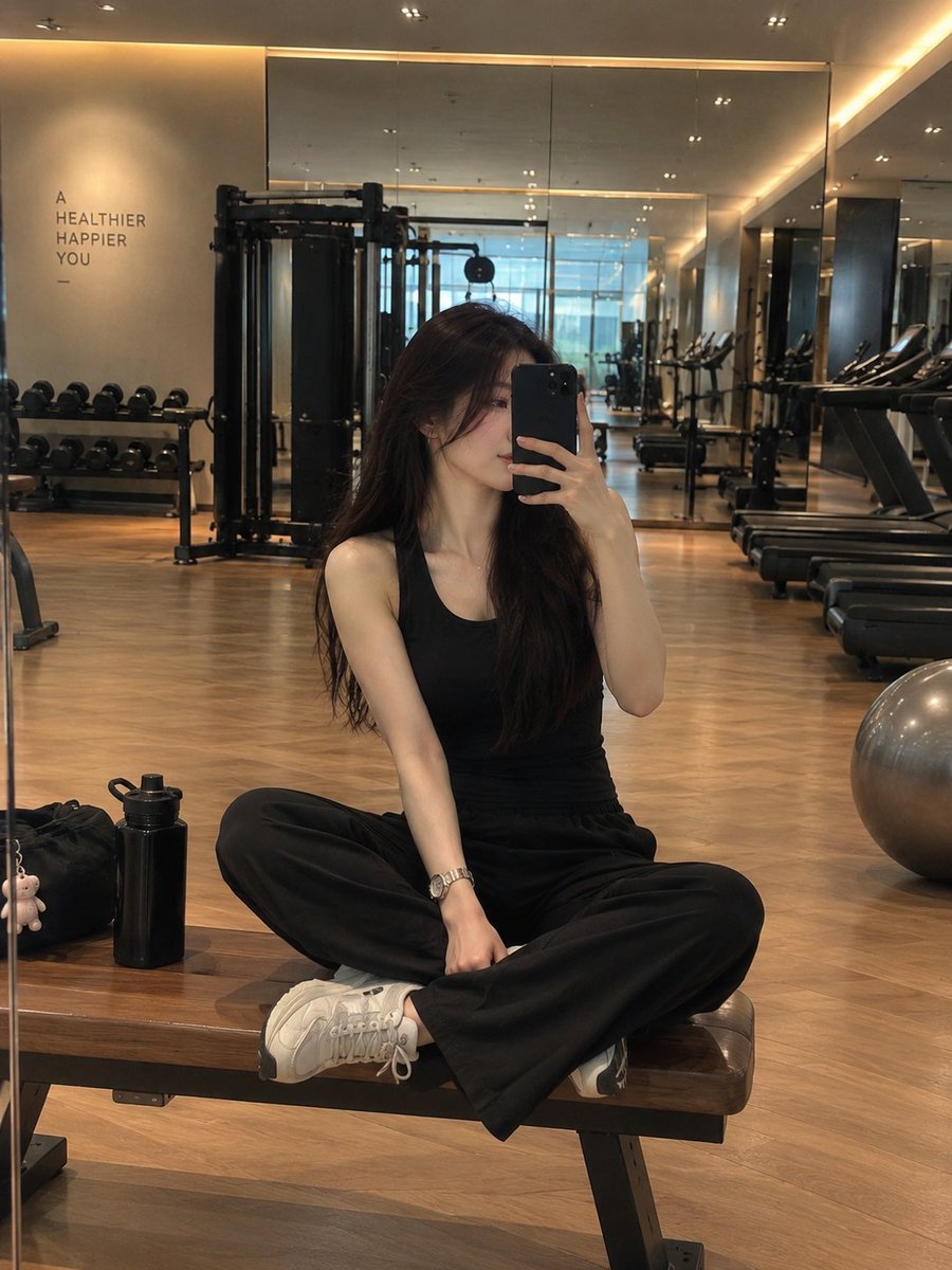 A stylish young woman taking a mirror selfie in a modern ...