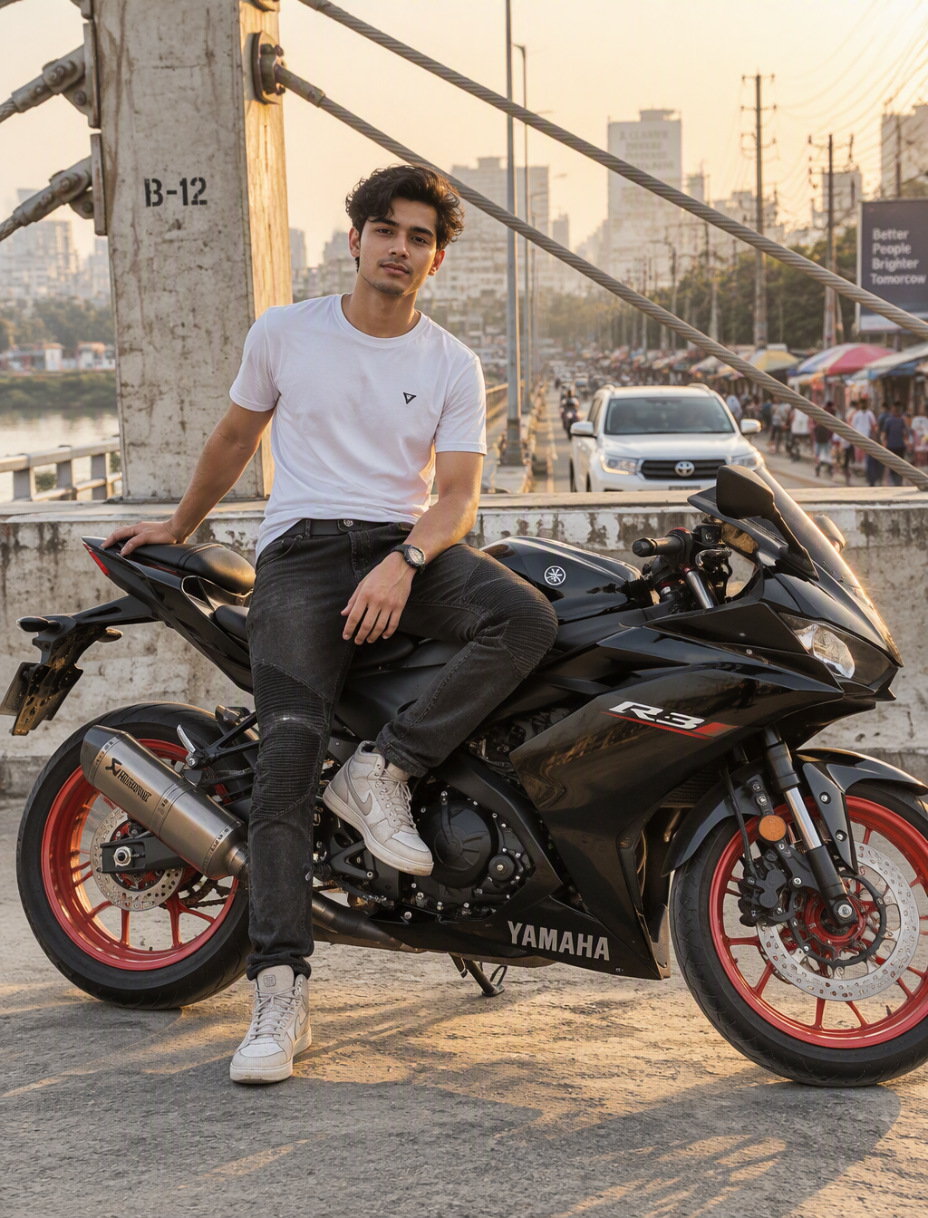 A young man sits astride a black sport motorcycle on a co...