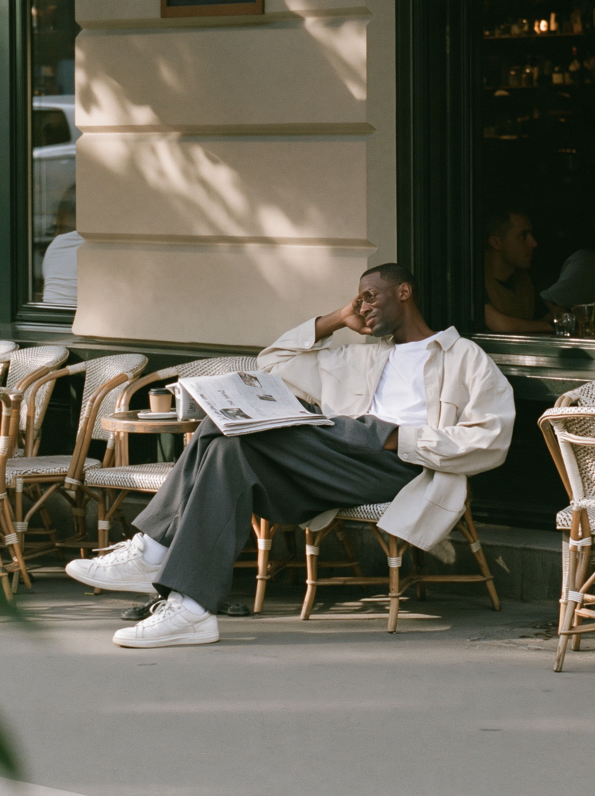 candid street photograph, Black man in his thirties sitti...