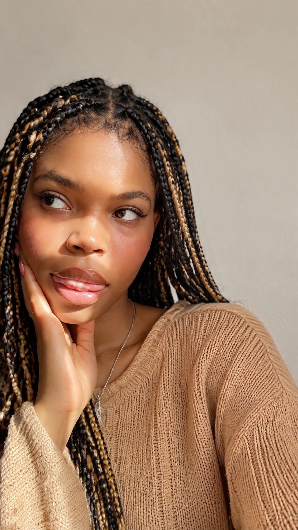 A young woman with intricate black and blonde box braids ...