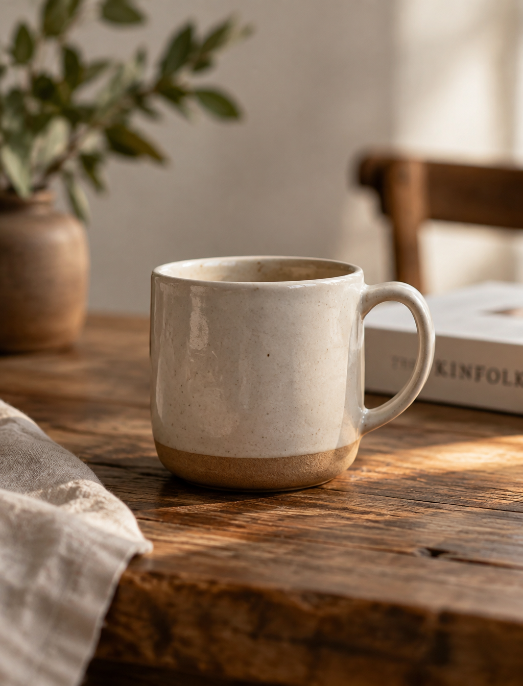 a minimalist ceramic mug in warm natural light on a rusti...