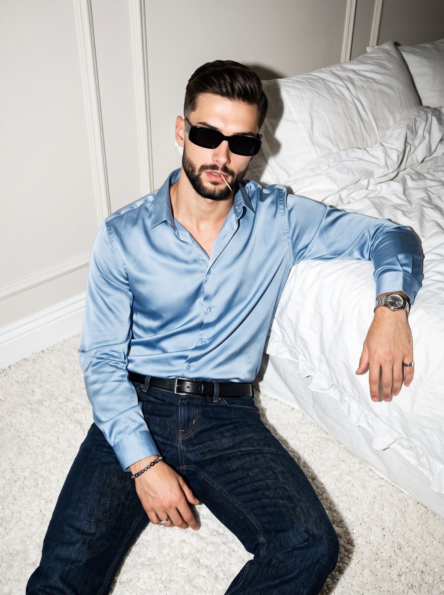 A young male model sits confidently on a white shag carpe...