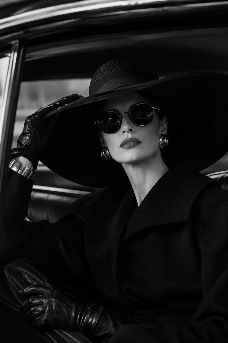 Elegant woman sitting inside a classic luxury car, wearin...